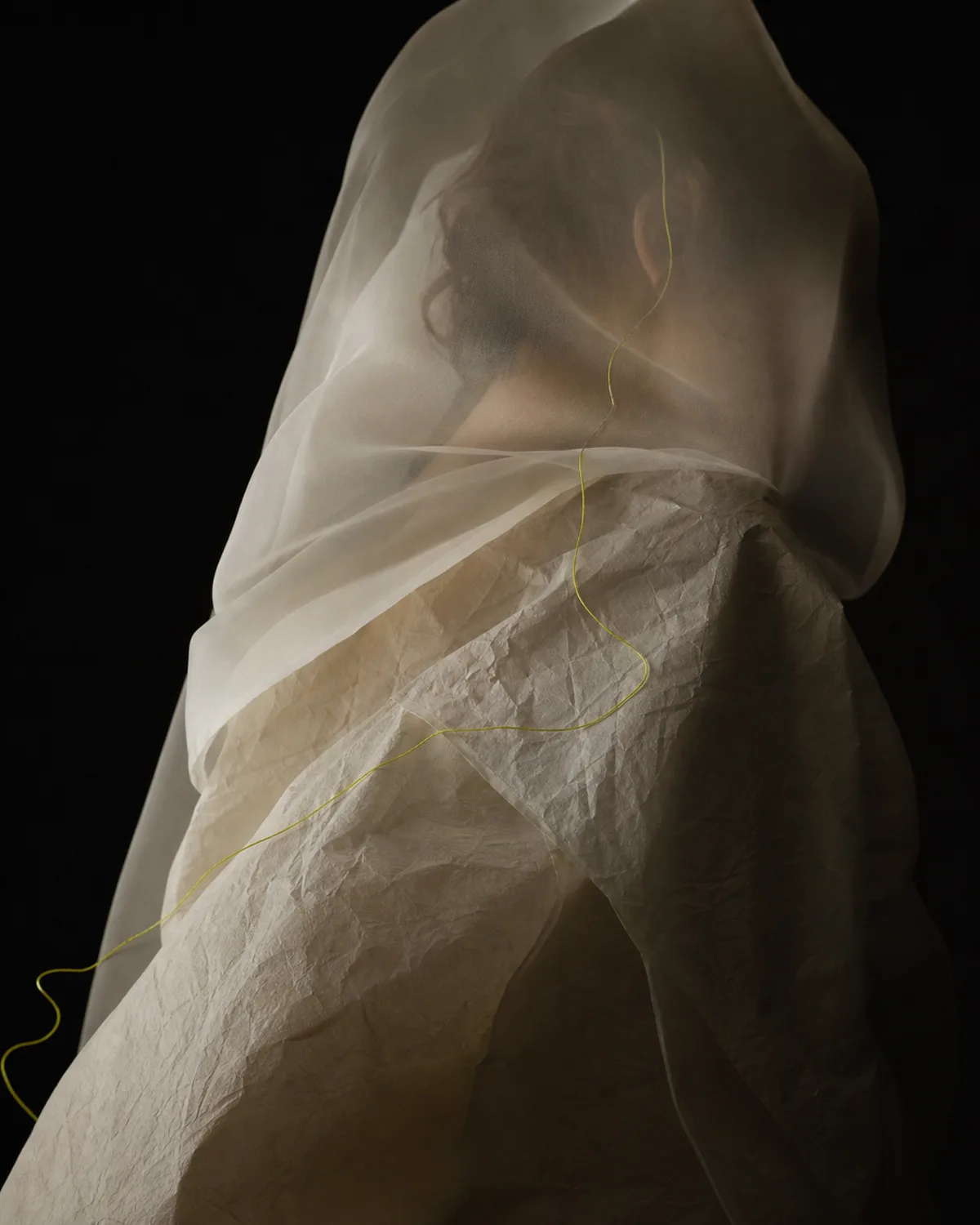 An abstract fashion editorial composition of translucent fabric and a fine thread.